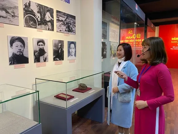 Hướng dẫn viên giới thiệu với khách tham quan triển lãm. Ảnh: QĐNDO