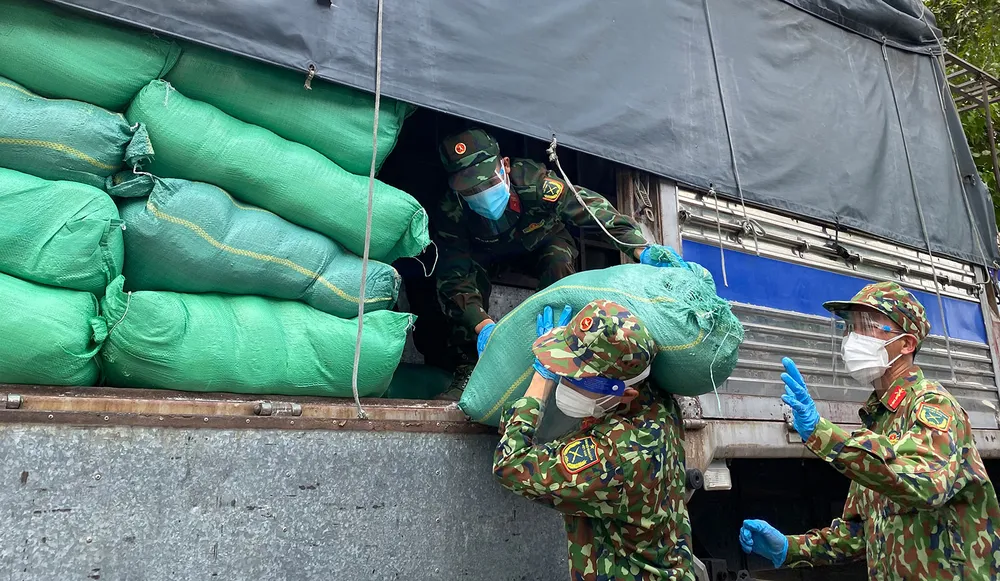 Bộ đội bốc dỡ gạo, thực phẩm, nhu yếu phẩm cung ứng đến các phường tại quận 6, sáng 28-8. Ảnh: CAO THĂNG