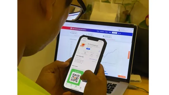 Người dân tìm hiểu ứng dụng PC-Covid. Ảnh: HOÀNG HÙNG