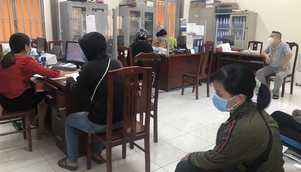 Người lao động là F0 làm thủ tục nhận giấy hoàn thành cách ly tại UBND phường 5, quận Gò Vấp. Ảnh: BÙI ANH TUẤN