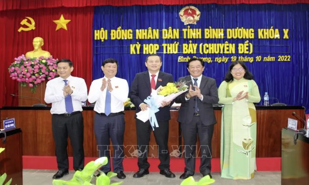 Chủ tịch HĐND tỉnh Bình Dương Phạm Văn Chánh nhận hoa của lãnh đạo Tỉnh ủy, UBND tỉnh sau khi cho thôi làm nhiệm vụ đại biểu HĐND nhiệm kỳ 2021-2026. Ảnh: TTXVN