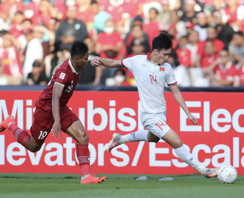 Tuyển thủ Hoàng Đức (14) nỗ lực đi bóng trong trận bán kết lượt đi Việt Nam - Indonesia