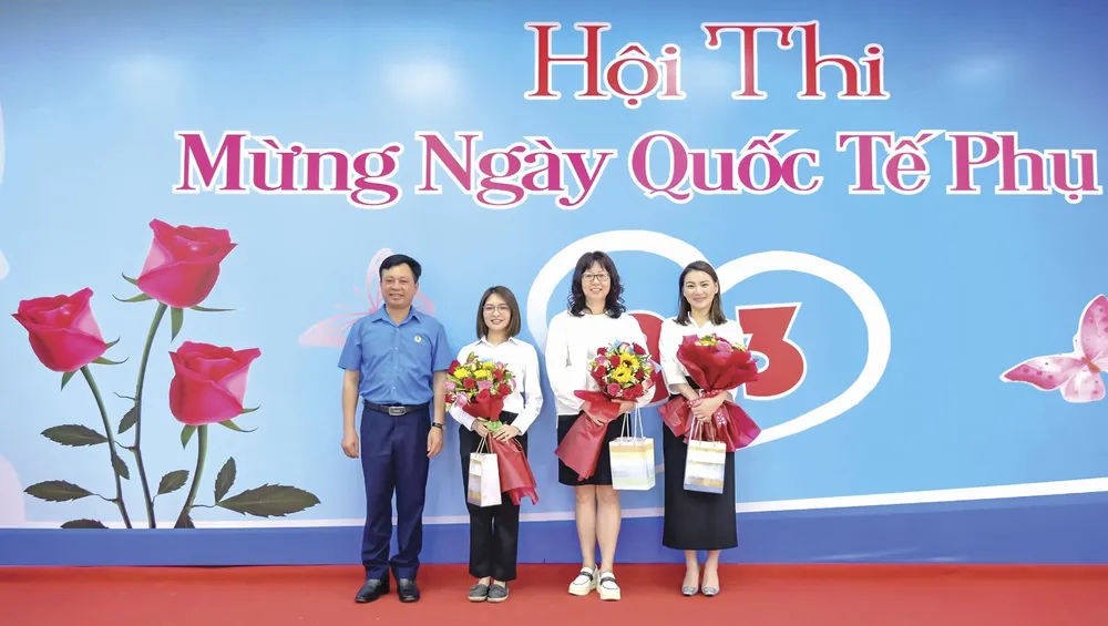 Ông Phạm Trung Thuyên - Chủ tịch Công đoàn (áo xanh) trao hoa và quà cho các nữ cán bộ nhân viên nước ngoài
