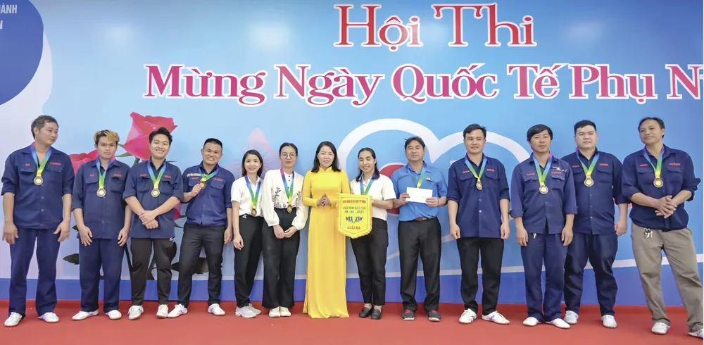 Bà Lê Thị Thanh Nguyệt - Ủy viên Ban chấp hành, Chủ tịch Liên đoàn Lao động huyện Long Thành (áo dài vàng) trao giải cho đội đoạt giải ba hội thi kéo co