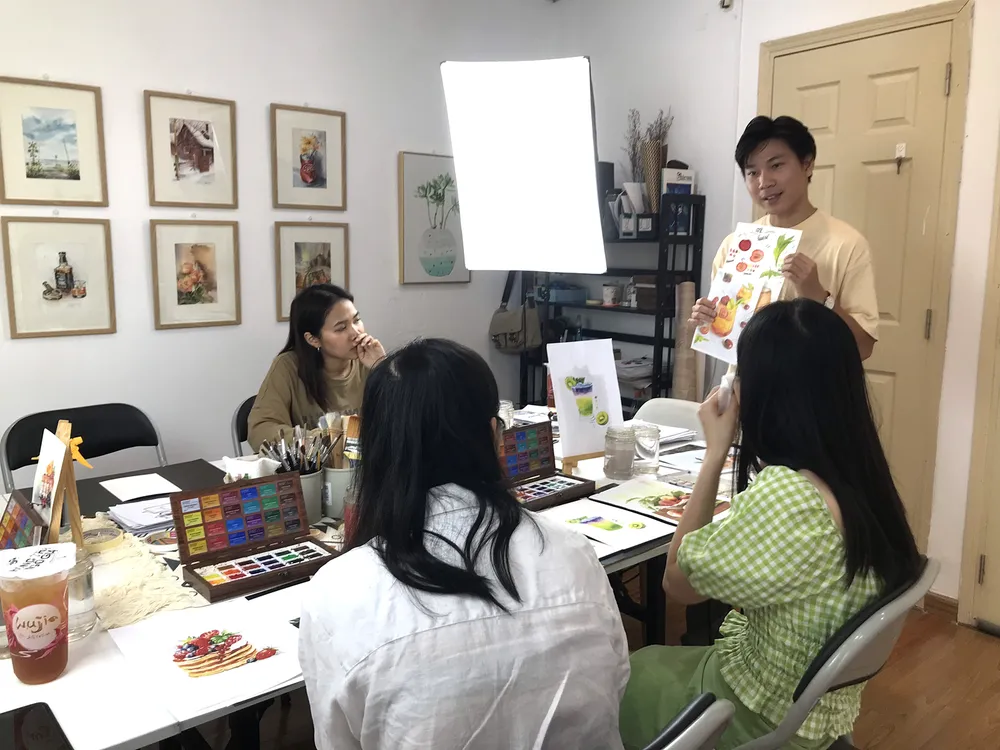 Họa sĩ hướng dẫn học viên phân tích màu tại một lớp học vẽ