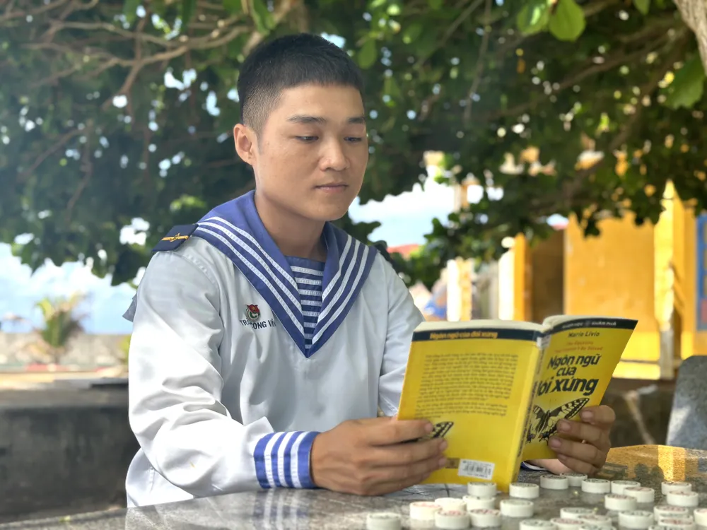 Tranh thủ lúc rảnh rỗi, chiến sĩ Trần Công Vĩnh tìm đến sách. Ảnh: HỒ SƠN