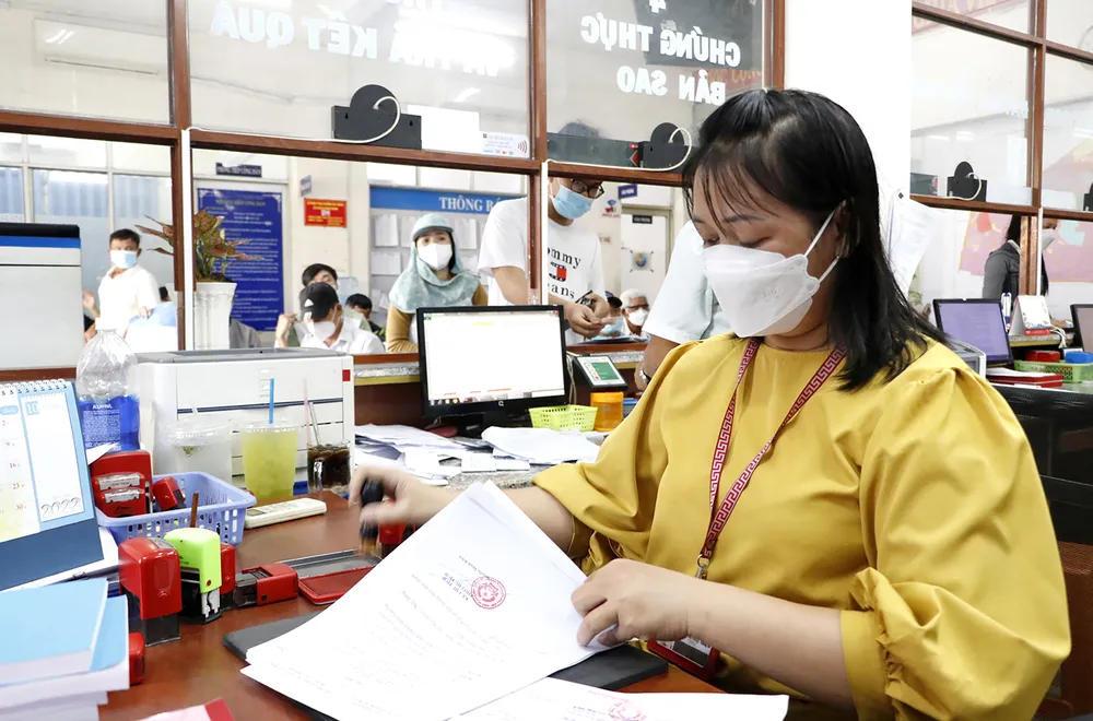 Mỗi ngày, chị Phạm Thị Ngọc Dung, công chức phường Bình Hưng Hòa A, quận Bình Tân giải quyết hơn 150 hồ sơ của người dân. Ảnh: NGÔ BÌNH