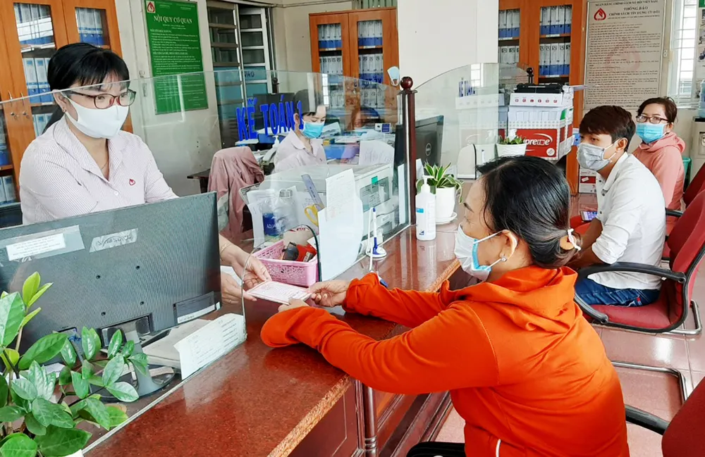 Người dân làm thủ tục vay vốn ưu đãi tại Ngân hàng Chính sách xã hội huyện Củ Chi. Ảnh: NGÔ BÌNH