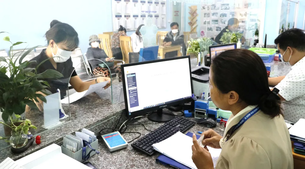 Công chức phường An Phú Đông, quận 12 giải quyết hồ sơ cho người dân. Ảnh: NGÔ BÌNH