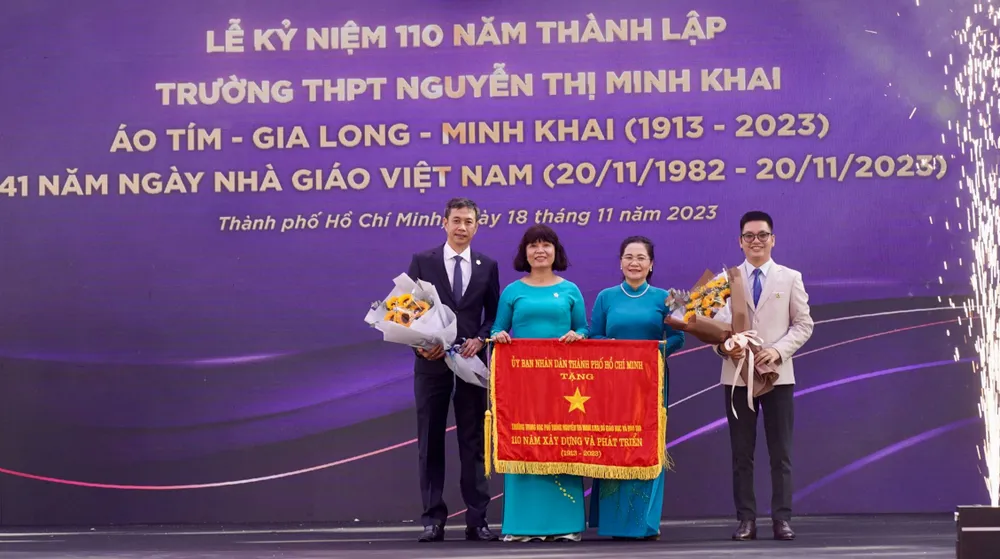 Đồng chí Nguyễn Thị Lệ trao tặng Cờ truyền thống đến tập thể Trường THPT Nguyễn Thị Minh Khai. Ảnh: HOÀNG HÙNG