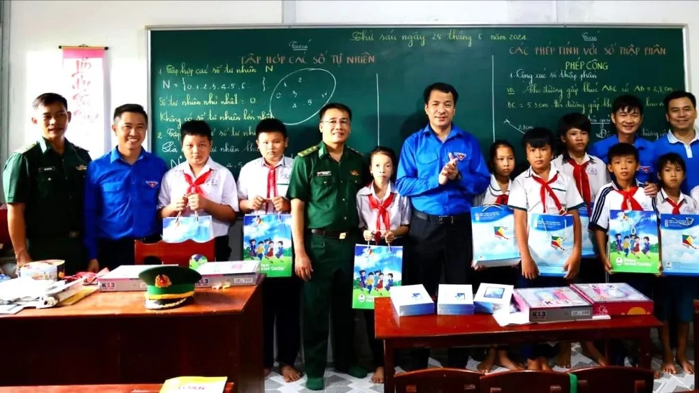 2. Đồng chí Ngô Văn Cương, Bí thư Ban Chấp hành Trung ương Đoàn (thứ 7 từ trái qua) tặng quà các em học sinh lớp học tình thương.jpg