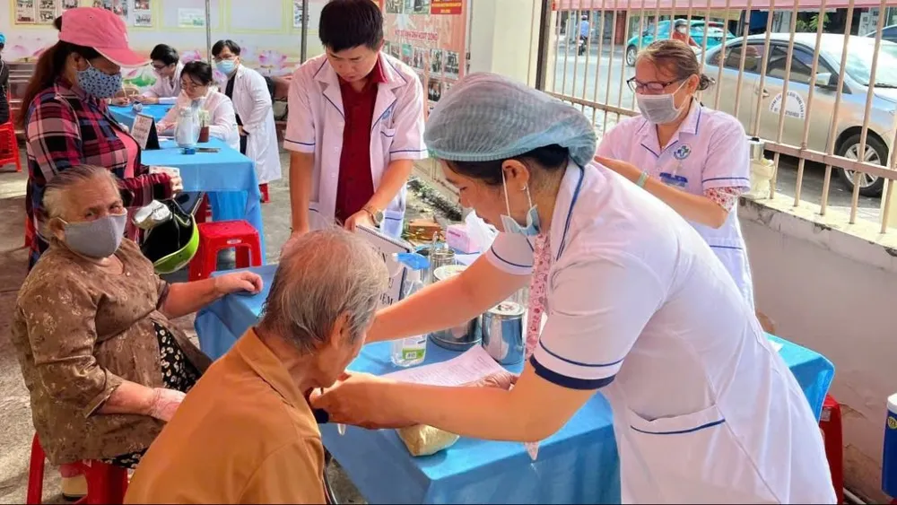 Nhân viên y tế đang lấy máu kiểm tra sức khỏe cho người cao tuổi phường Phú Lâm, TPHCM