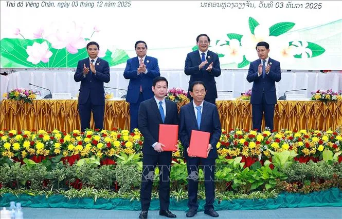 Thủ tướng Phạm Minh Chính và Thủ tướng Lào Sonexay Siphandone chứng kiến trao biên bản hợp tác giữa doanh nghiệp hai nước. Ảnh: DƯƠNG GIANG/TTXVN