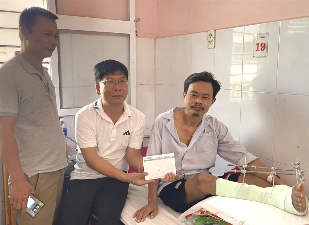 Đại diện Báo SGGP trao tiền cho anh Lê Văn Toán