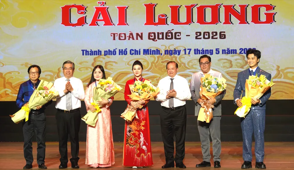 Thứ trưởng Bộ VH-TT-DL Tạ Quang Đông và Phó Bí thư Thành ủy, Chủ tịch Ủy ban MTTQ Việt Nam TPHCM Nguyễn Phước Lộc tặng hoa cho Ban giám khảo "Cuộc thi tài năng diễn viên cải lương toàn quốc - 2026". Ảnh: THÚY BÌNH