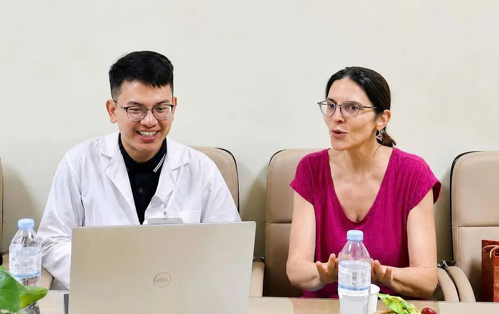 Bác sĩ Lê Hồng Thái (trái) trao đổi chuyên môn với TS-BS Delphine Natali (Pháp) tại Bệnh viện K (Ảnh: NVCC)