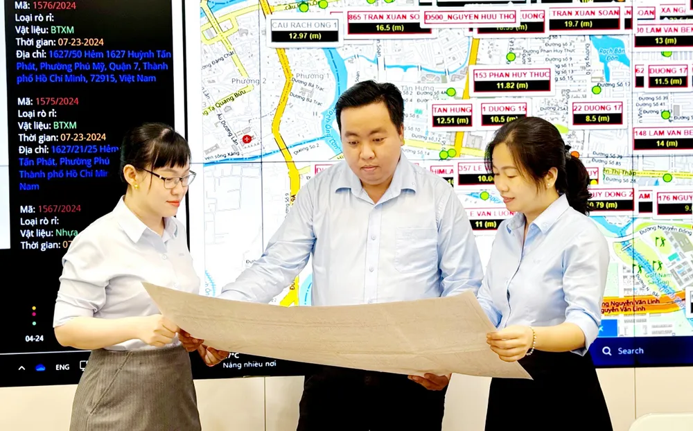 Kỹ sư Nguyễn Minh Hoàng (giữa), Công ty CP Cấp nước Nhà Bè, cùng đồng nghiệp nghiên cứu các cải tiến mới. Ảnh: THÁI PHƯƠNG