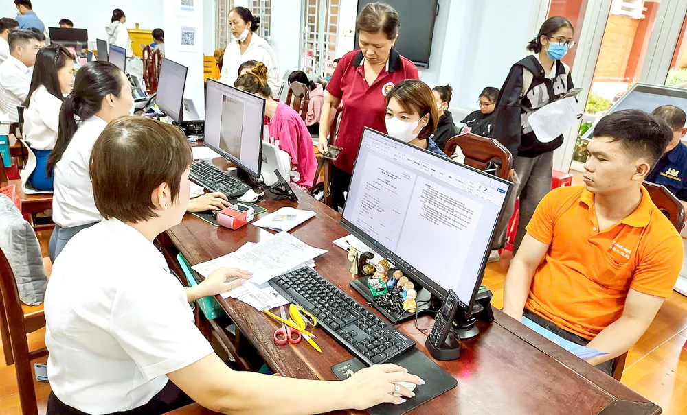 Chuyên viên Trung tâm Phục vụ hành chính công phường Đông Hòa tiếp và giải quyết thủ tục hành chính của người dân. Ảnh: THU HƯỜNG