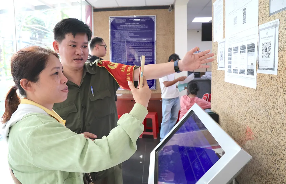 Lực lượng tham gia bảo vệ an ninh, trật tự ở cơ sở và cán bộ phường luôn túc trực để hướng dẫn người dân cài đặt ứng dụng