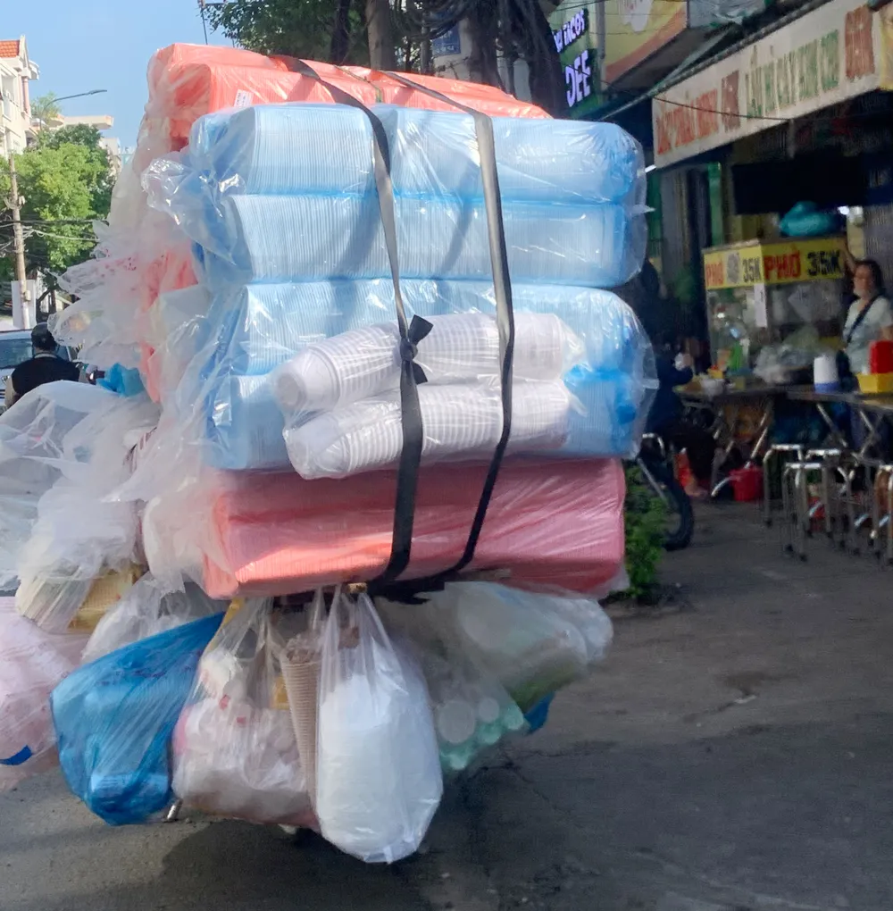 Chiếc xe máy chở hàng cồng kềnh, quá khổ, di chuyển nhanh trên đường
