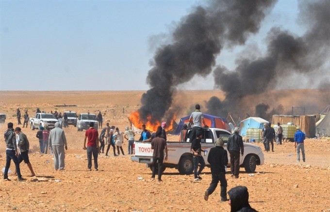 Smoke billows during clashes between Tunisian protesters and security forces outside the El Kamour oil and gas pumping station, in the southern state of Tataouine, on May 22, 2017. — AFP/VNA