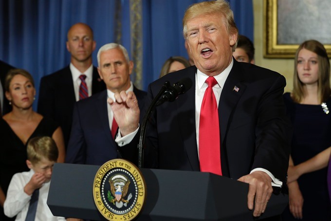 US President Donald Trump delivers s statement on healthcare in front of alleged "victims of Obamacare" at the White House in Washington on July 24. — AFP/VNS