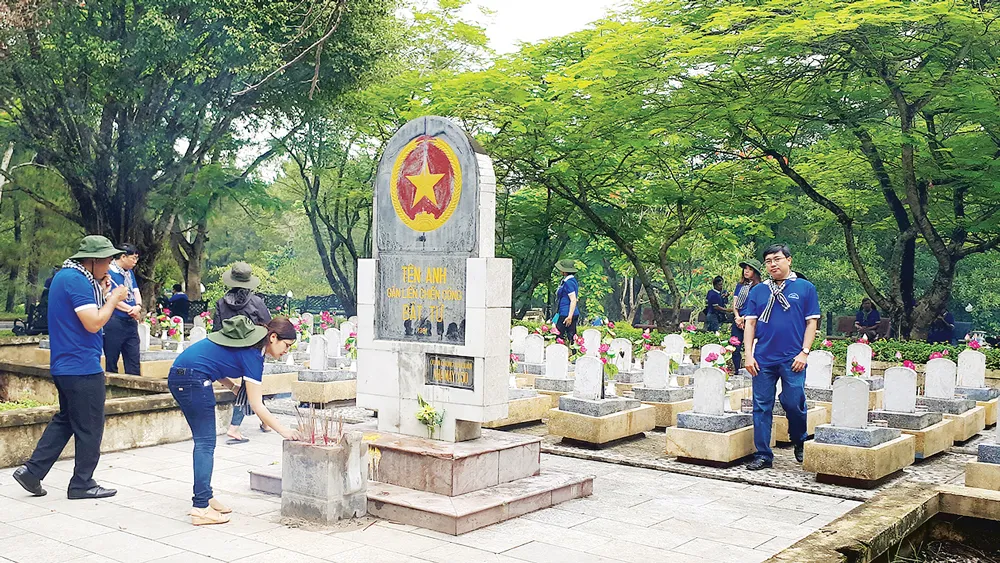 Đoàn “Hành trình tri ân - Tiếp lửa truyền thống” của Đảng ủy Khối Dân - Chính - Đảng TPHCM viếng Nghĩa trang Liệt sĩ Quốc gia Trường Sơn, tháng 7-2017. Ảnh: TRÍ THẾ