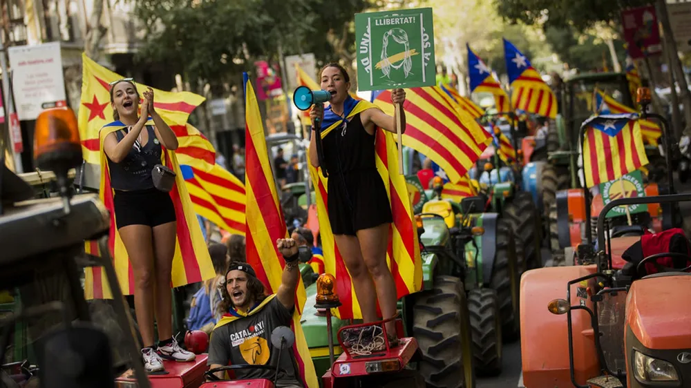Nông dân treo lá cờ độc lập của xứ Catalonia trên đầu máy kéo trong một cuộc biểu tình ở Barcelona. Ảnh: AP