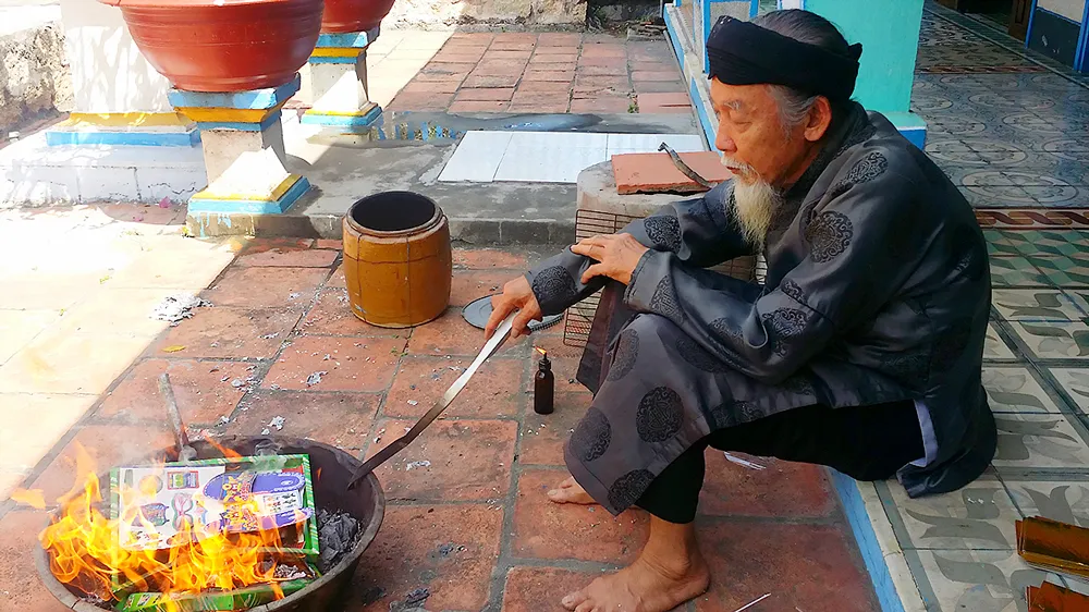 Một người dân ở xã đảo Long Sơn (Vũng Tàu) đốt vàng mã cho người cháu đã mất. Ảnh: VŨ ANH