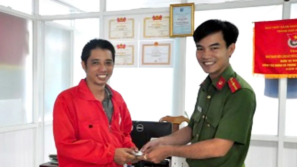 Thiếu úy Văn Ngọc Cường trao lại tiền và giấy tờ cho anh Hoàng Trọng Hiếu