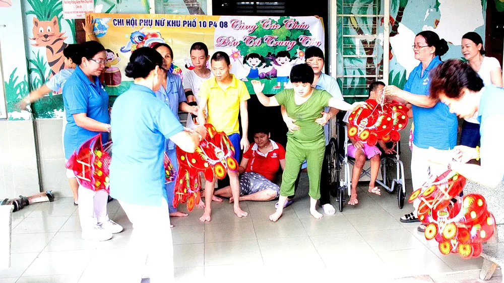 Chi hội Phụ nữ khu phố 10 (phường 4, quận 8, TPHCM) trao quà tặng các em tại Trung tâm Bảo trợ trẻ tàn tật - mồ côi Thị Nghè. Ảnh: MINH THẢO