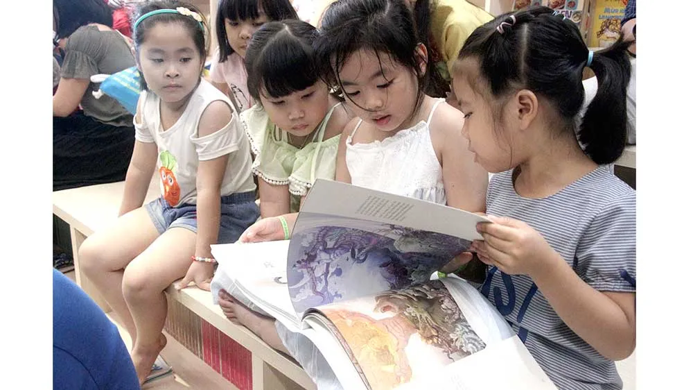 Bạn đọc nhí thích thú cuốn sách Thiện và Ác và Cổ tích - sách Artbook do NXB Kim Đồng ấn hành