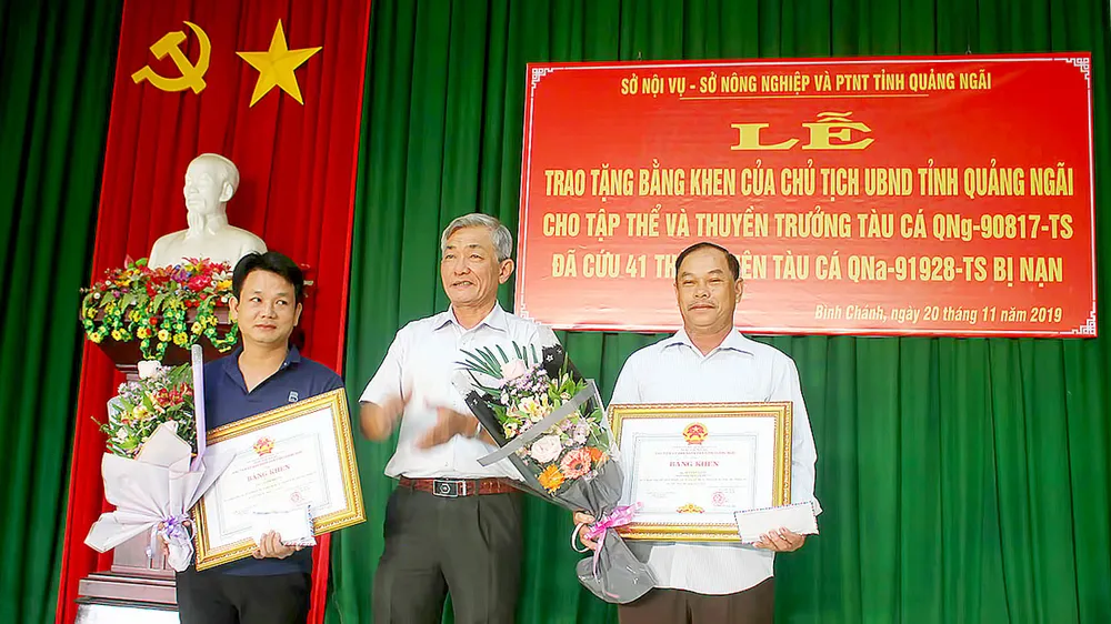 Thuyền trưởng Bùi Văn Danh (bên trái) và đại diện tập thể tàu cá QNg 90817 TS nhận bằng khen