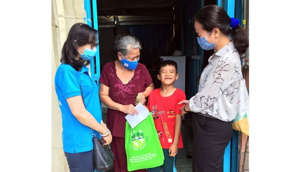 Tặng quà gia đình bà Võ Thị Phấn, huyện Bình Chánh. Ảnh: ĐẶNG NHUNG