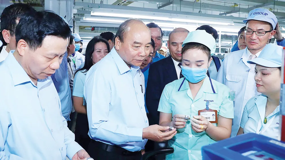 Thủ tướng Nguyễn Xuân Phúc tìm hiểu đời sống công nhân của Công ty TNHH điện tử Foster (Bắc Ninh). Ảnh: TTXVN