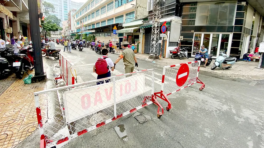 Phân luồng lối vào - lối ra giúp giao thông thông thoáng trước Trường Tiểu học Minh Đạo, quận 5. Ảnh: CAO THĂNG