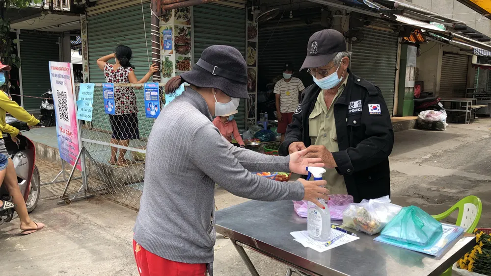 Người dân khai báo y tế, đo thân nhiệt, sát khuẩn khi vào mua sắm tại chợ An Hội (quận gò Vấp) sáng 9-7. Ảnh: BÙI ANH TUẤN