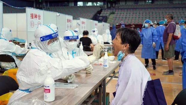 Nhân viên y tế lấy mẫu xét nghiệm Covid-19 cho người dân Trung Quốc. Ảnh: TTXVN