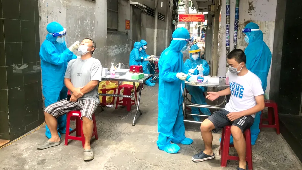 Anh Trần Bình An, sinh viên Trường Đại học Y khoa Phạm Ngọc Thạch (ngoài cùng bên trái) lấy mẫu xét nghiệm cho người dân