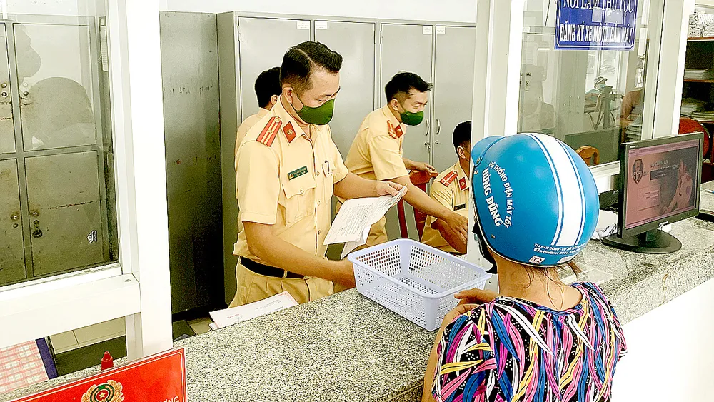 Người dân làm thủ tục đăng ký xe ở trụ sở Công an huyện Nhà Bè vào ngày 21-5. Ảnh: CHÍ THẠCH
