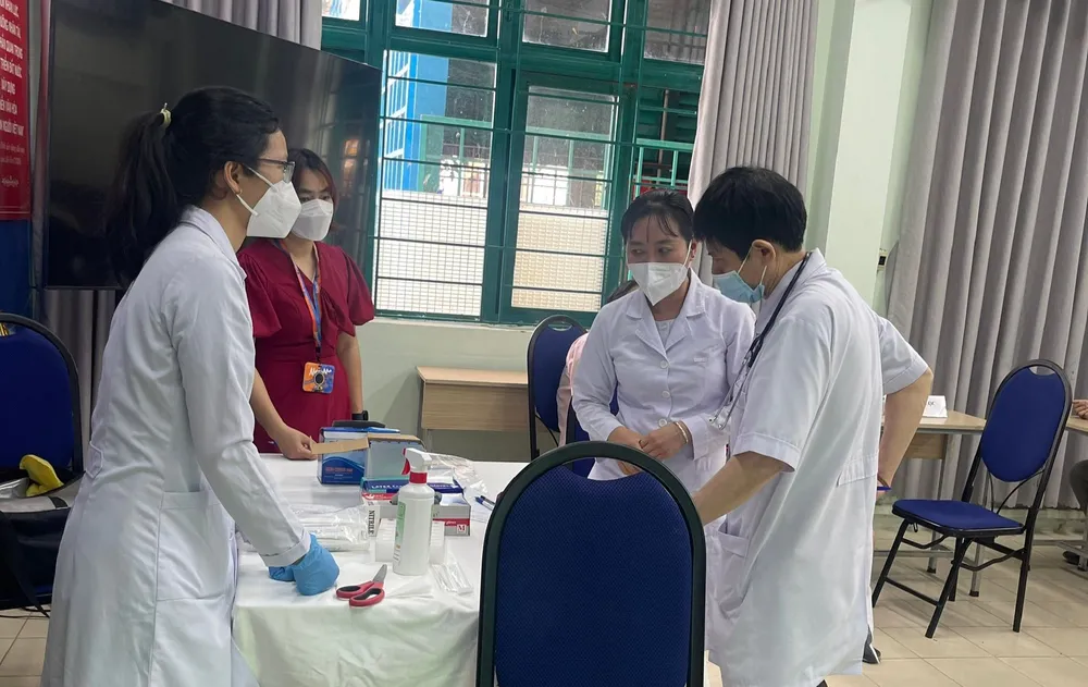 Nhân viên y tế lấy mẫu xét nghiệm cho học sinh Ảnh: HCDC