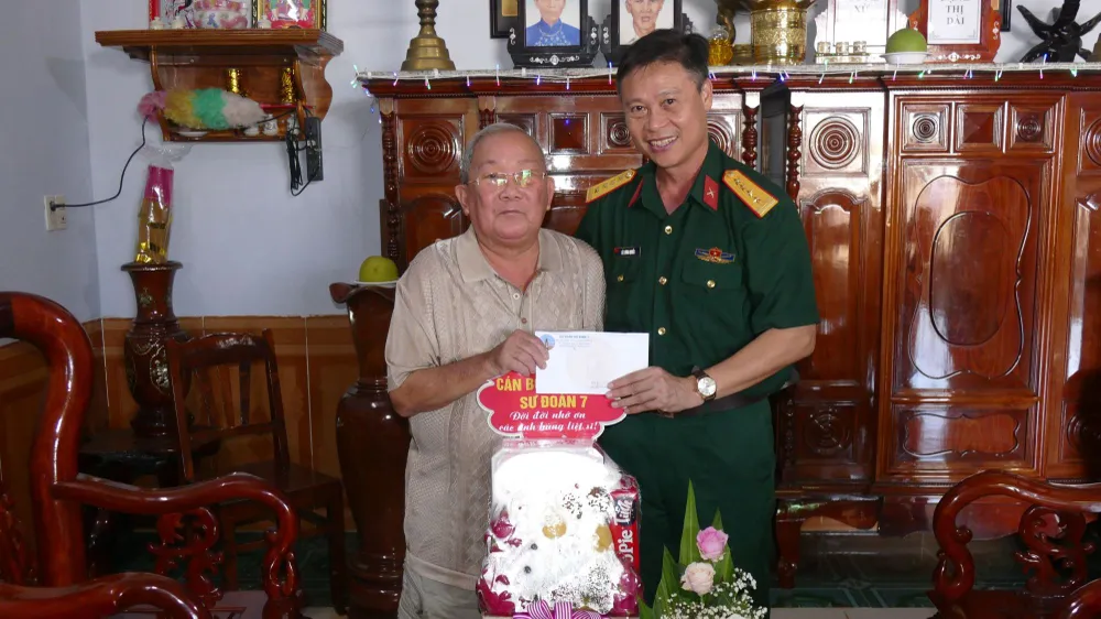 Đại tá Lê Lương Quyền trao quà cho bác Nguyễn Văn Trinh, là thân nhân của liệt sĩ tại thôn Bù Lư, xã Bù Gia Mập, huyện Bù Gia Mập