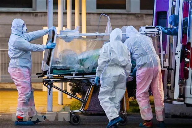 Nhân viên y tế chuyển bệnh nhân mắc Covid-19 (ở Rome, Italy, ngày 16-3-2020). Ảnh: TTXVN