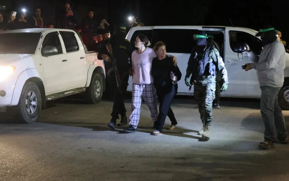 Các tay súng Hamas bàn giao nhóm con tin người Israel cho Ủy ban Chữ thập Đỏ Quốc tế tại Rafah, miền Nam Dải Gaza, ngày 28-11. Ảnh: TTXVN