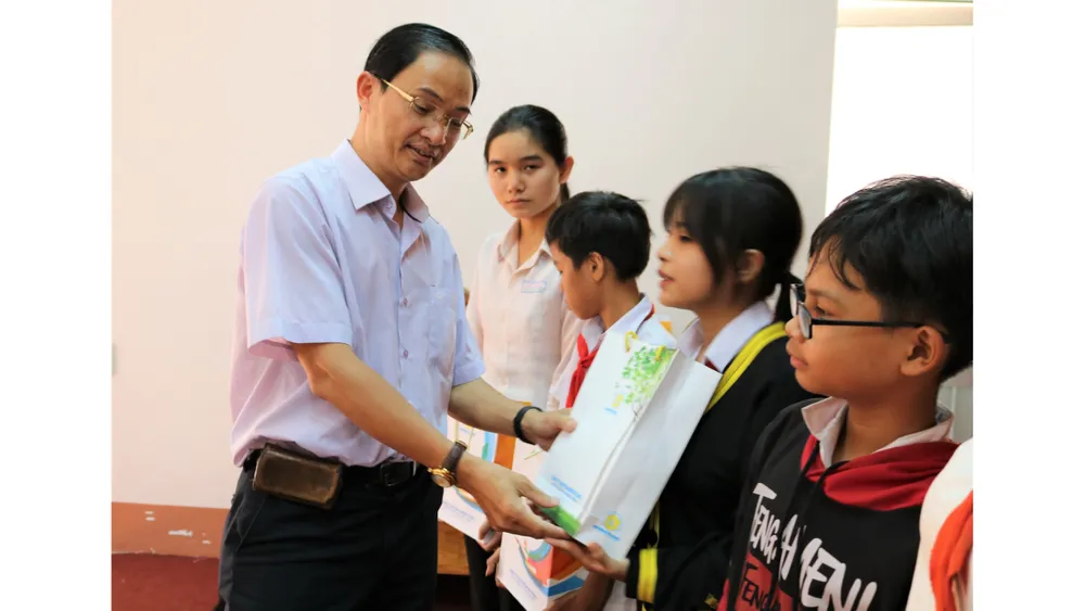 Nhà báo Trần Văn Phong, Trưởng Văn phòng đại diện Báo Sài Gòn Giải Phóng tại khu vực Đông Nam bộ, trao học bổng cho học sinh nghèo huyện Lộc Ninh