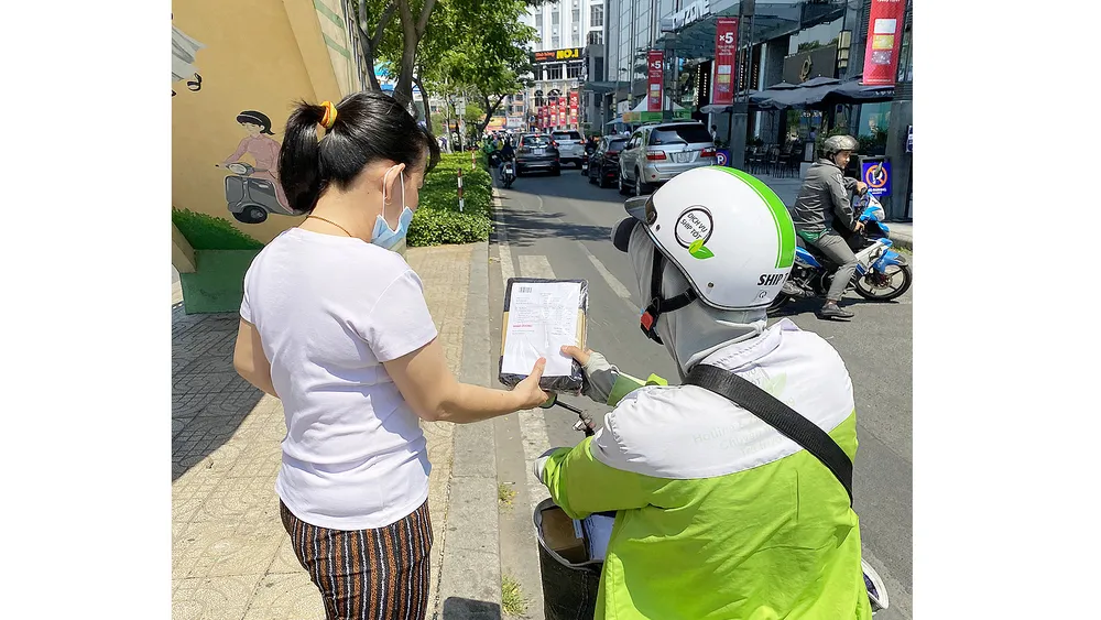 Nhận hàng đặt mua online. Ảnh: CAO THĂNG