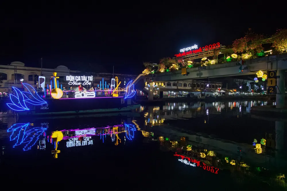 Những nghệ sĩ biểu diễn đờn ca tài tử Nam bộ phục vụ du khách tham quan và mua sắm. Hình chụp ngày 20-1-2023, tại chợ hoa xuân "Trên bến dưới thuyền" ở quận 8.