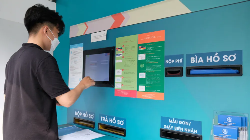 Người dân nộp và nhận hồ sơ qua hệ thống tiếp nhận và trả kết quả hồ sơ tự động tại UBND quận 6, TPHCM. Ảnh: VĂN MINH