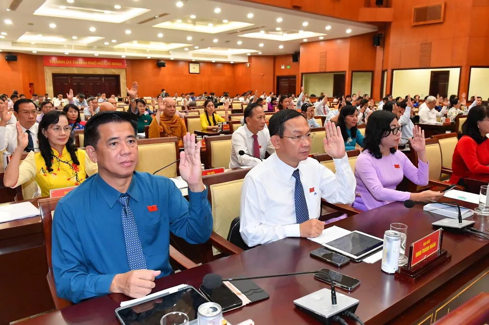 Các đại biểu biểu quyết thông qua các nghị quyết. Ảnh: VIỆT DŨNG