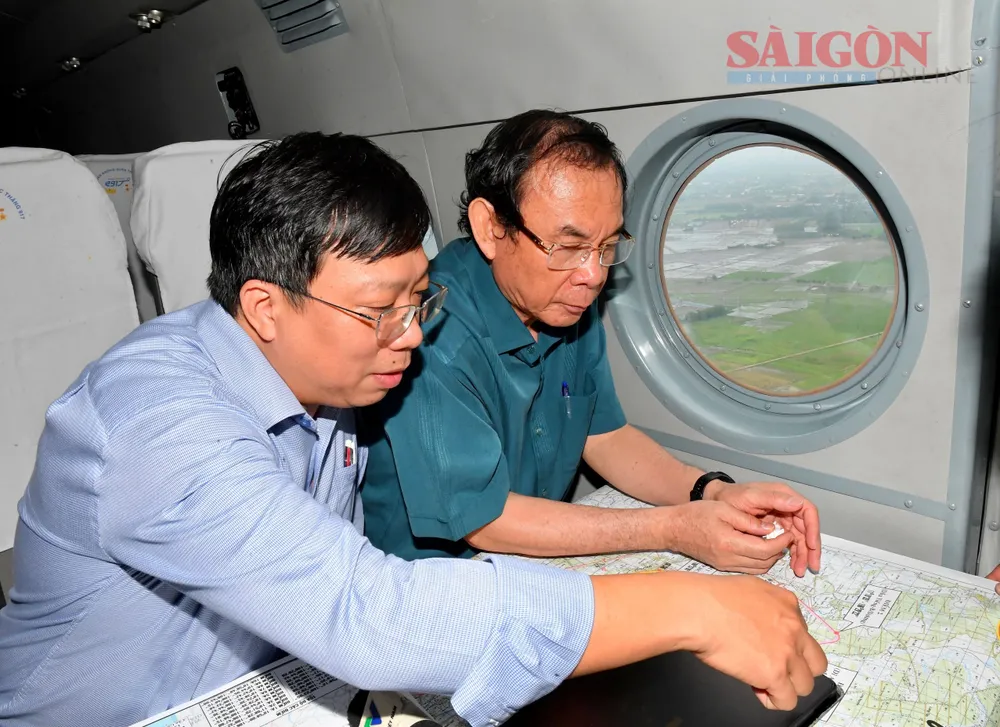 Bí thư Thành ủy TPHCM Nguyễn Văn Nên và Giám đốc Sở QH-KT Nguyễn Thanh Nhã trao đổi trên chuyến bay khảo sát về công tác quy hoạch TPHCM. Ảnh: VIỆT DŨNG